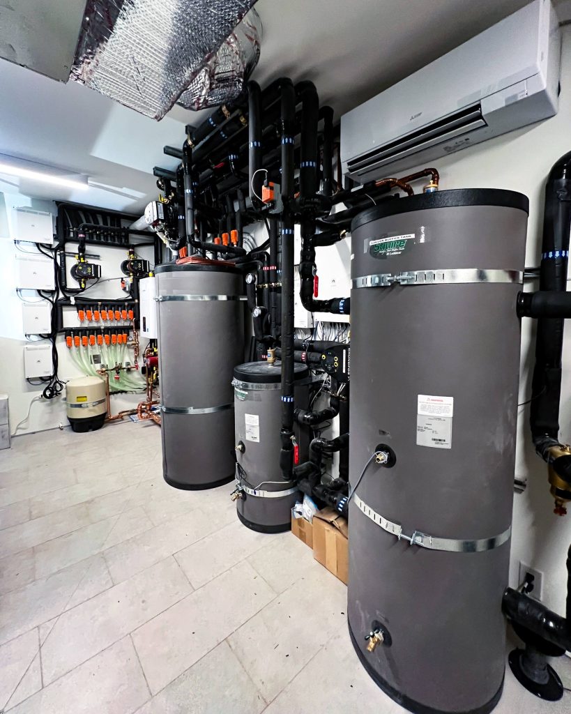 Mechanical room for a 4-pipe hydronic system that utilizes a single air-to-water heat pump to generate chilled water for hydronic cooling, while two boilers produce hot water for hydronic heating.